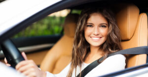 Young woman driving car - Loan vs. Lease